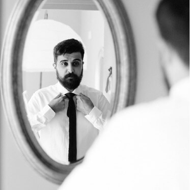 Photo d'un marié qui se regarde dans le miroir, création de bijoux sur mesure lille.